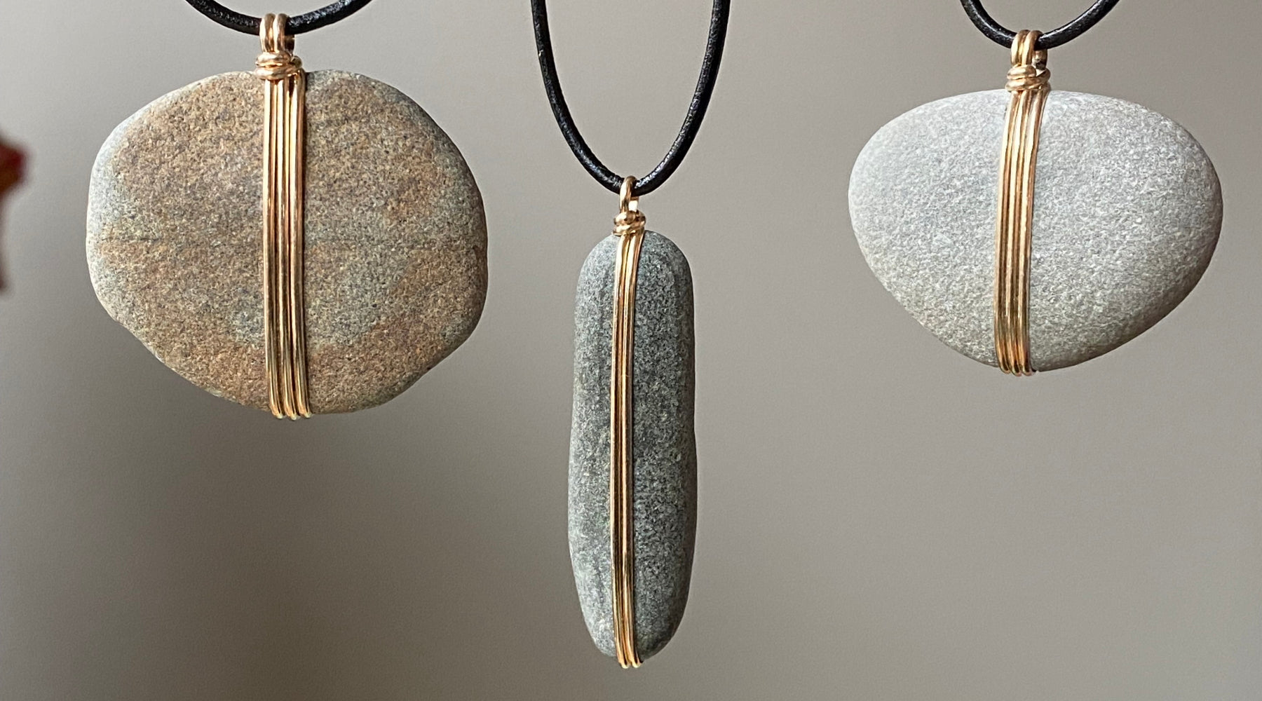Beach stone pendants wrapped with gold or silver wire. 