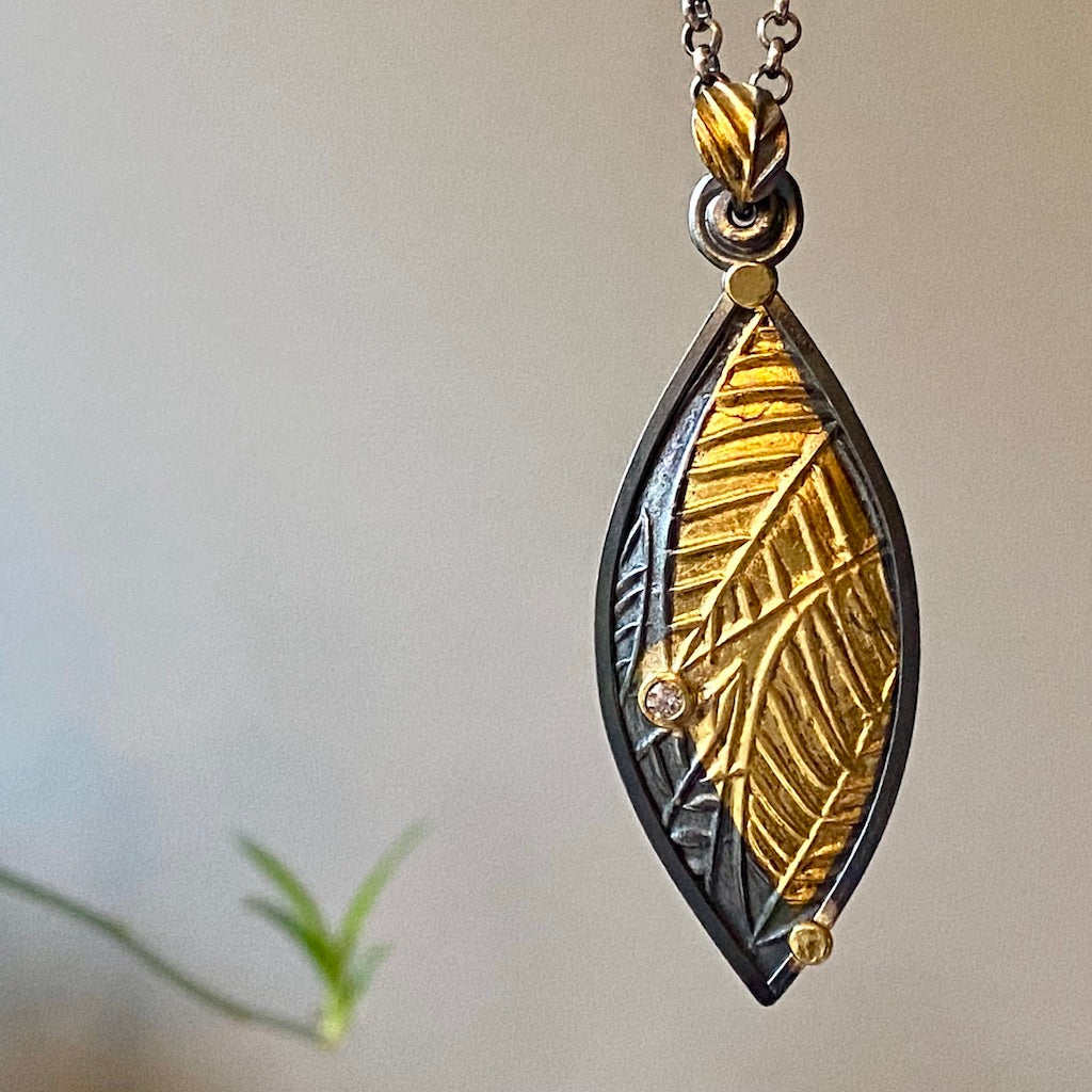 Flow pendant. Oxidized Argentium and fine silver, 22-karat and 24-karat gold, diamond on an 18-inch oxidized silver chain.